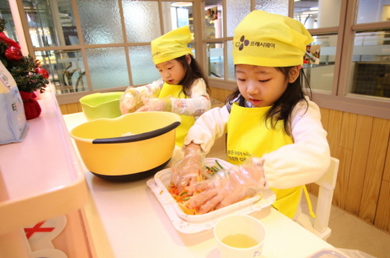 CJ프레시웨이의 ‘건강한 식문화 쿠킹클래스’에 참여한 아이들이 샐러드를 손수 만들고 있다.