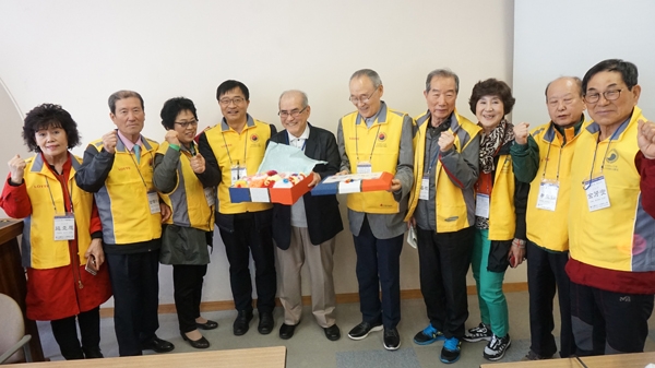대한노인회 노인자원봉사 일본 연수단의 정지걸 단장(오른쪽에서 두 번째)이 고베 행복촌 운영자 야마다 다키시씨와 선물을 교환하고 있다