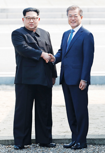 문재인 대통령과 북한 김정은 국무위원장이 4월 27일 오전 9시 30분, 판문점 군사분계선에서 악수하고 있다. 두 정상은 이날 남측 평화의 집에서 오전, 오후 두 차례 정상회담을 가졌다. 	사진=연합뉴스