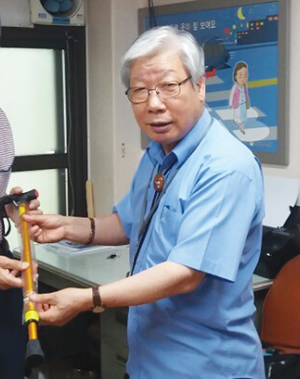 배정웅 서울 관악구지회 부지회장이 새 지팡이를 선물하고 있다.