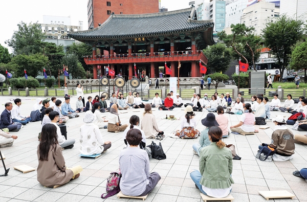 세계평화의날을 맞아 서울 종로구 보신각 앞에서 열린 행사에서 참가자들이 명상을 하는 모습이다. 	사진=연합뉴스