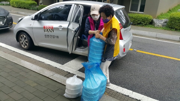 지회 직원과 자원봉사자들이 직접 포장한 삼계탕을 어르신들에 전달하기 위해 차에 싣고 있다.