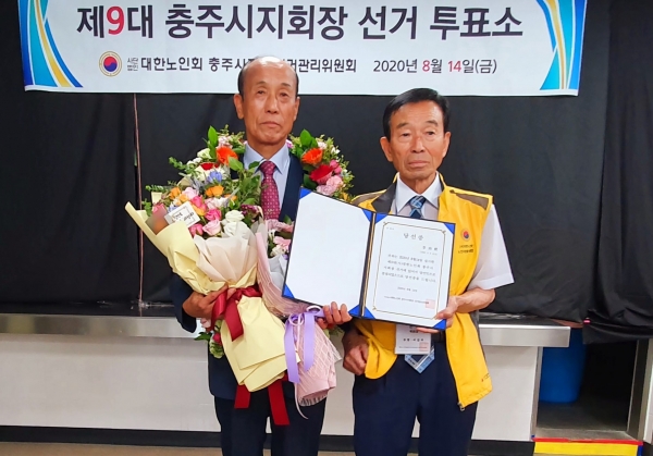 재선된 이상희 지회장(왼쪽)이 이길주 선거관리위원장으로부터 당선증을 받고 기념촬영을 하고 있다.