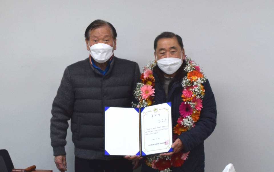 김동량 지회장(오른쪽)이 당선 확정 후  최봉수 선거관리위원장(왼쪽)에게 당선증을 받고 기념사진을 촬영하고 있다.