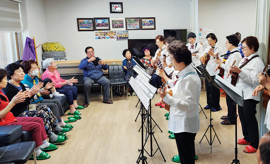 아름다운선율봉사단원들이 복지시설에서 어르신들에게 우쿨렐레 연주를 들려주고 있다.