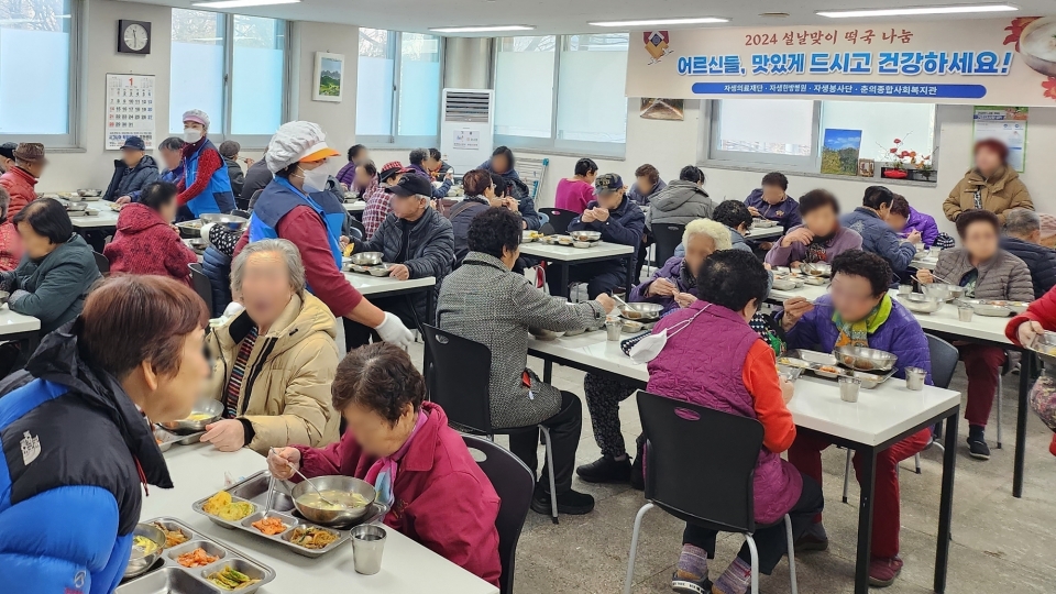 자생한방병원 봉사단원들이 부천시 춘의종합사회복지관에서 노인들에게 설음식을 제공하고 있다.