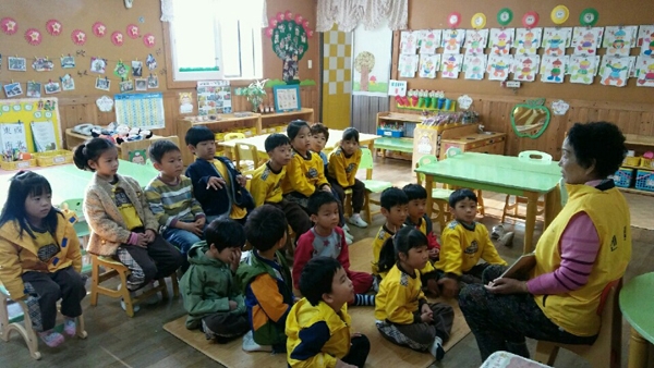 대한노인회 목포시지회의 보육교사도우미가 어린이집에서 아이들에게 그림책을 보여주고 있다.