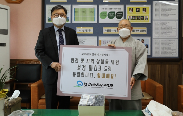 강익구 한국노인인력개발원장(왼쪽)이 4월 2일 일산노인종합복지관에 마스크를 기부하고 복지관장인 지언스님과 포즈를 취했다.