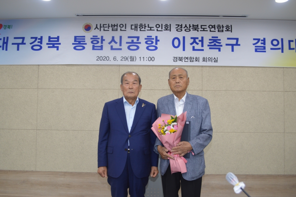 양재경 연합회장이 봉화군지회장으로 재선된 신명준 지회장에게 축하의 꽃다발을 주고 기념사진을 찍고 있다.