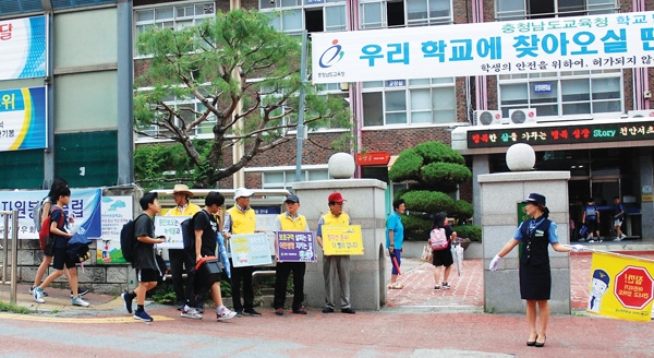 대한노인회 충남 천안시지회 소속 경우회노인자원봉사클럽 회원들이 학교 앞에서 교통질서 안내를 하고 있다.
