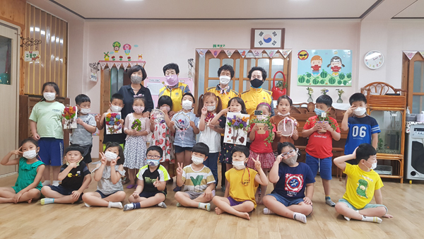 대한노인회 경남 남해군지회의 들풀향기봉사클럽 회원들이 아이들과 함께 만든 작품을 들고 기념촬영했다.