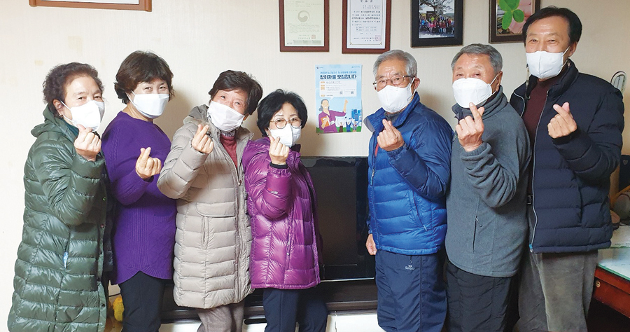 경북 구미시 남통e편한세상A경로당 회원들이 노인일자리 홍보 포스터를 경로당에 부착한 뒤 ‘손하트’를 표하고 있다.