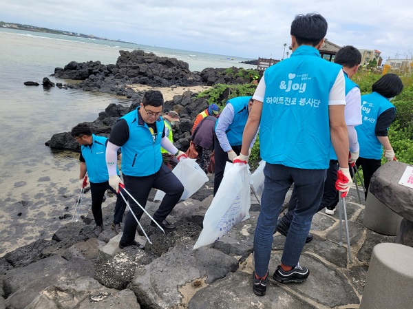 하이트진로 제주지점 임직원들과 서귀포시 바다환경지킴이가 지난 8일 표선해수욕장의 쓰레기를 수거하고 있다.(사진=하이트진로)